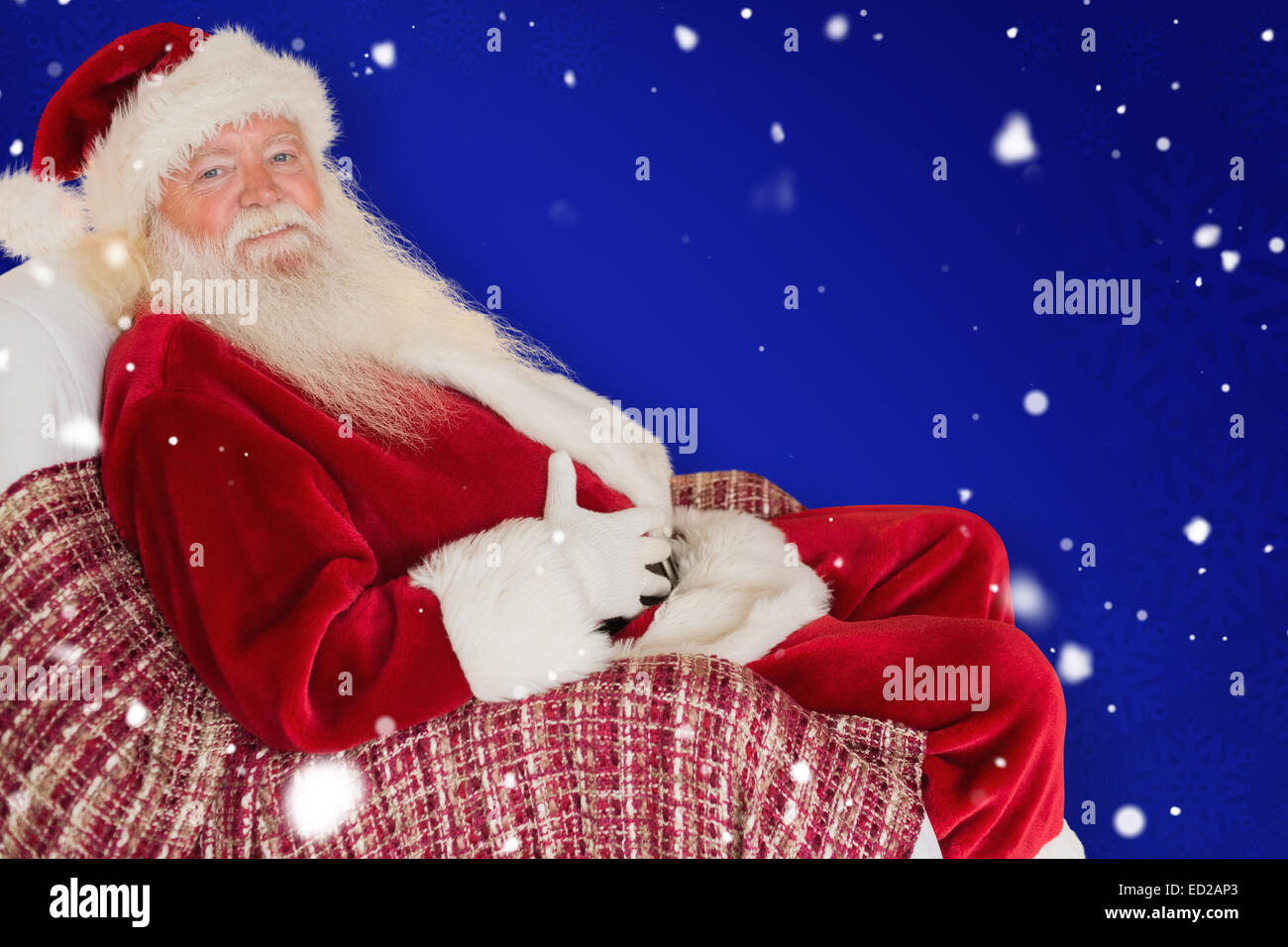 Composite image of santa holding his belly on the armchair Stock Photo ...