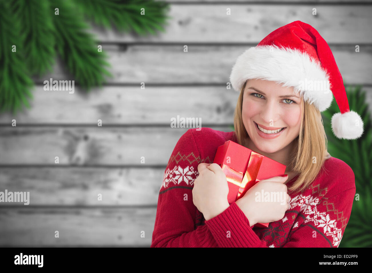 Composite image of woman holding christmas present Stock Photo - Alamy