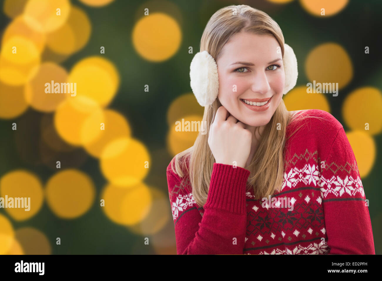 Composite image of woman wearing warm ear muffs Stock Photo