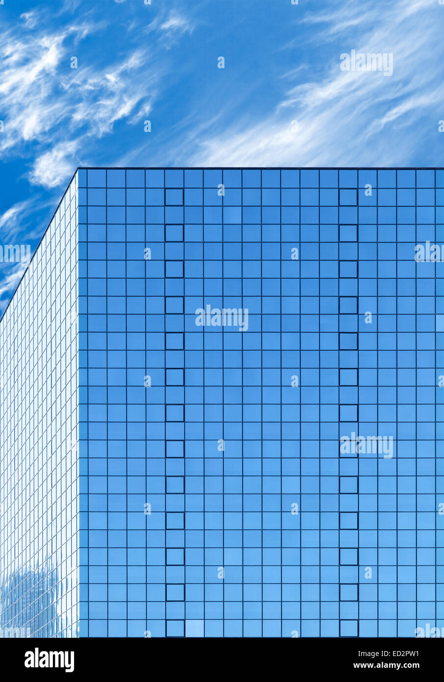 Modern office building made of blue glass and cloudy sky on a background Stock Photo