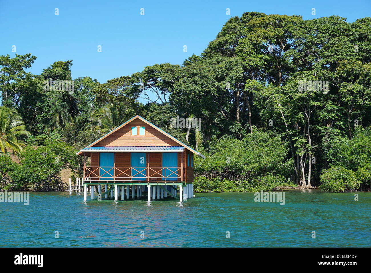 Bungalow over the sea with tropical vegetation in background, Caribbean, Bocas del Toro, Panama Stock Photo