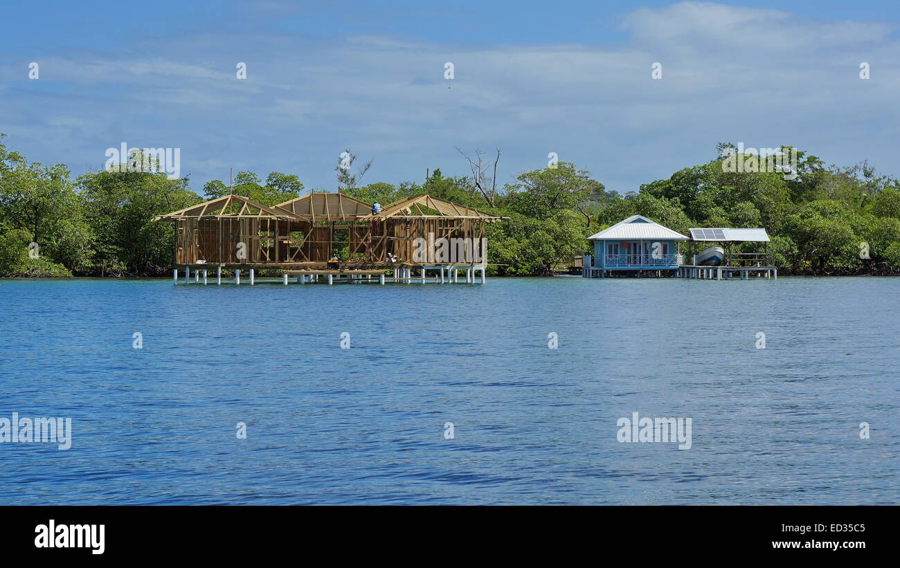 New wooden tropical house construction over the sea close to a bungalow with boathouse, Caribbean, Bocas del Toro, Panama Stock Photo