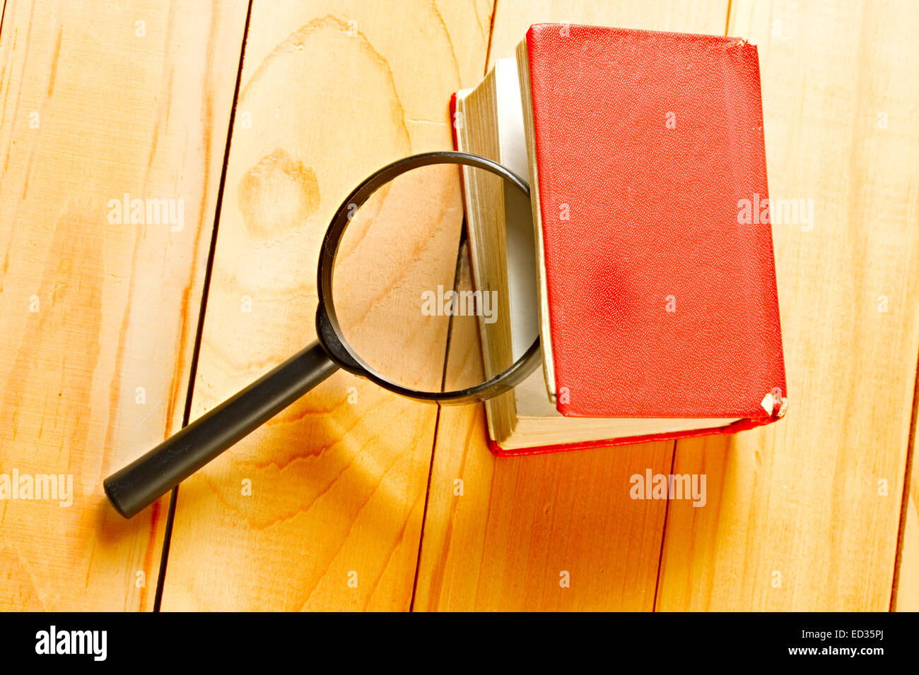 Magnifying glass and book on the wooden background Stock Photo - Alamy