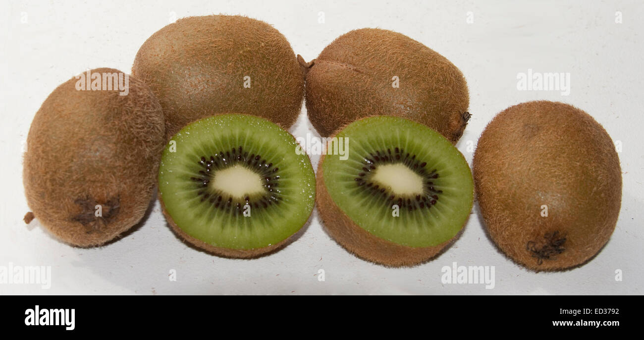 Group of fresh kiwi fruit / Chinese gooseberry, one cut in half showing bright green flesh, on plain white background Stock Photo