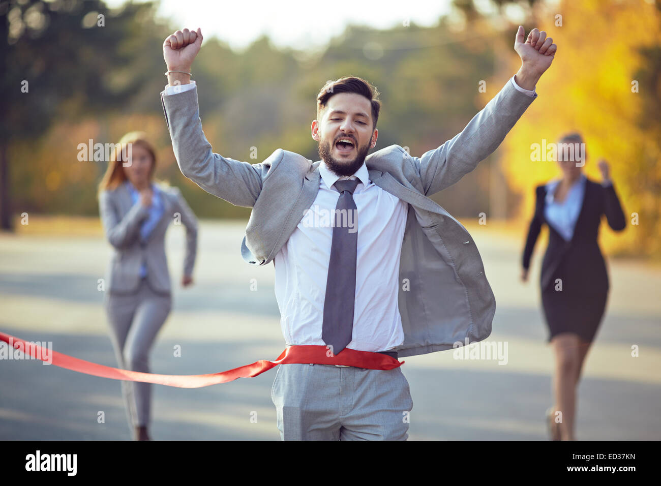 To Finish Winning businessman coming to finish with two female colleagues on ...