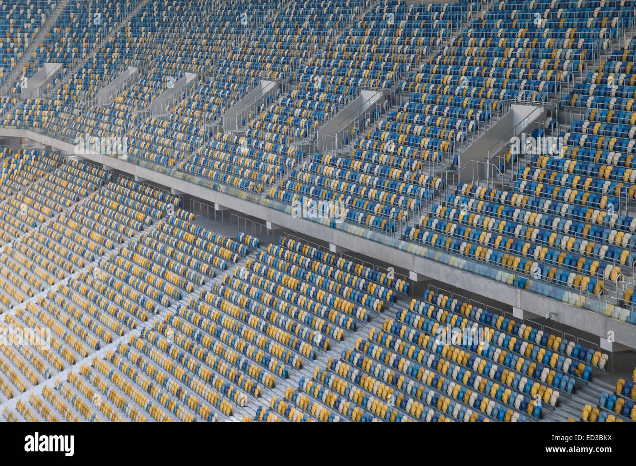 This is a field of empty stadium seats - Ukraine. Seats are painted a yellow and a blue. Stock Photo