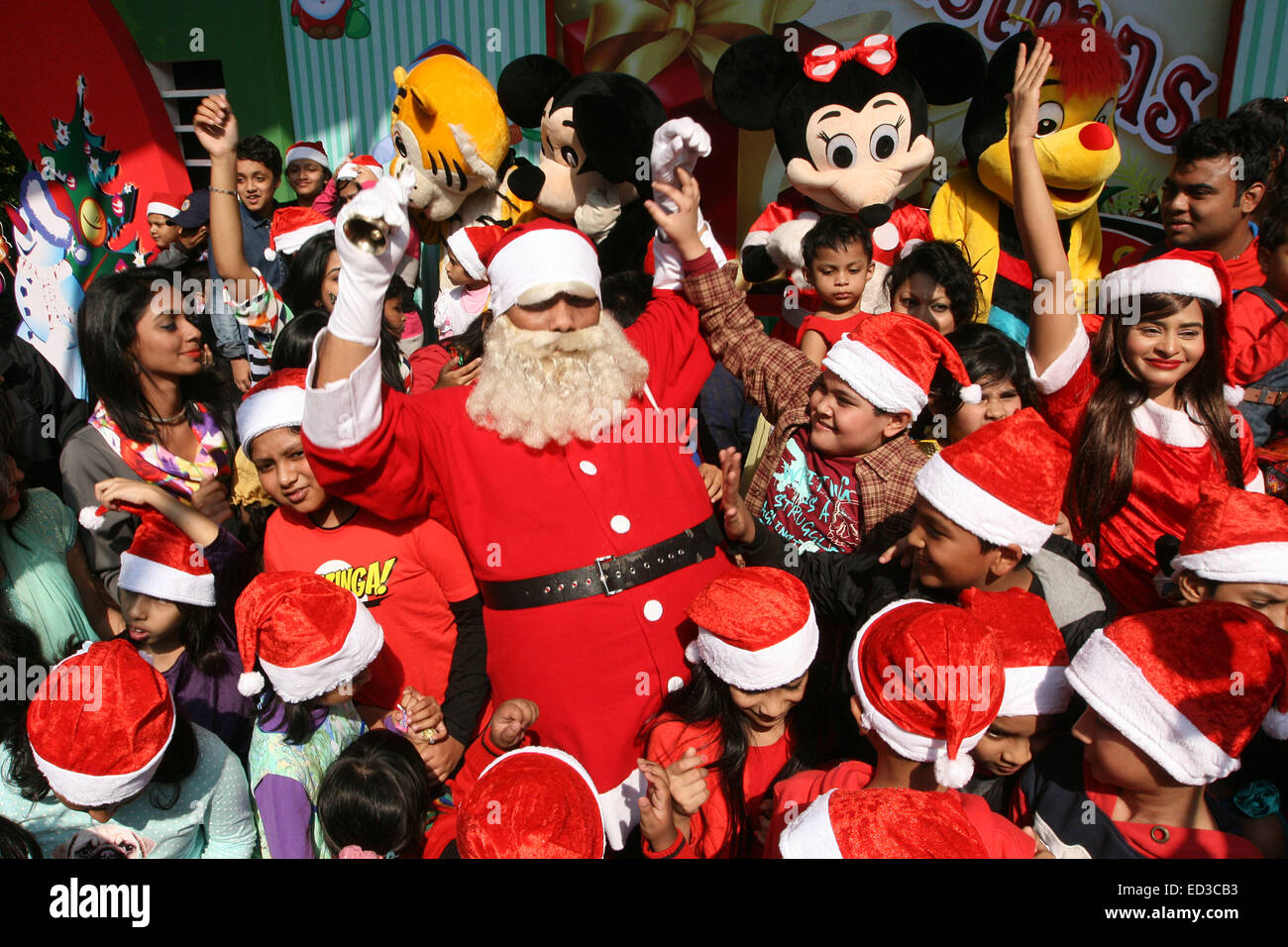 Santa Claus poses with Bangladeshi children for photographs during a  Christmas party in Dhaka on December 25, 2014 Stock Photo - Alamy