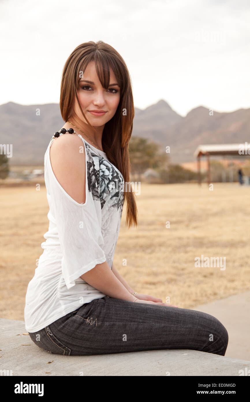Young woman in white blouse looking at camera Stock Photo - Alamy