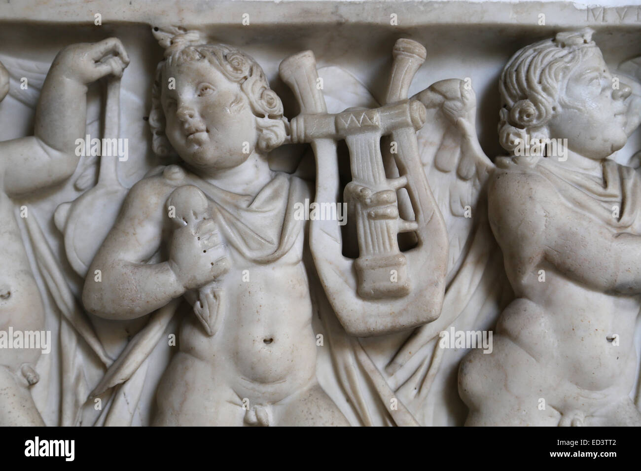 Roman art. Front panel of the sarcophagus adorned with a relief. Eros playing musicals instruments. Vatican Museums. Stock Photo