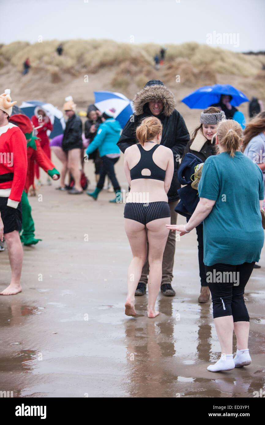 Carmarthenshire, Wales, UK. 26th Dec, 2014. Pembrey Sands, Cefn Sid, Carmarthenshire, Wales, UK. Pembrey Sands Boxing day Walrus Dip. A very cold,windy and with heavy rain,rainy,day, for the 30th anniversary of the Walrus Dip. Brave swimmers endure the elements dressed in various fancy dress costumes for a brief dip in the freezing waters. Credit:  Paul Quayle/Alamy Live News Stock Photo