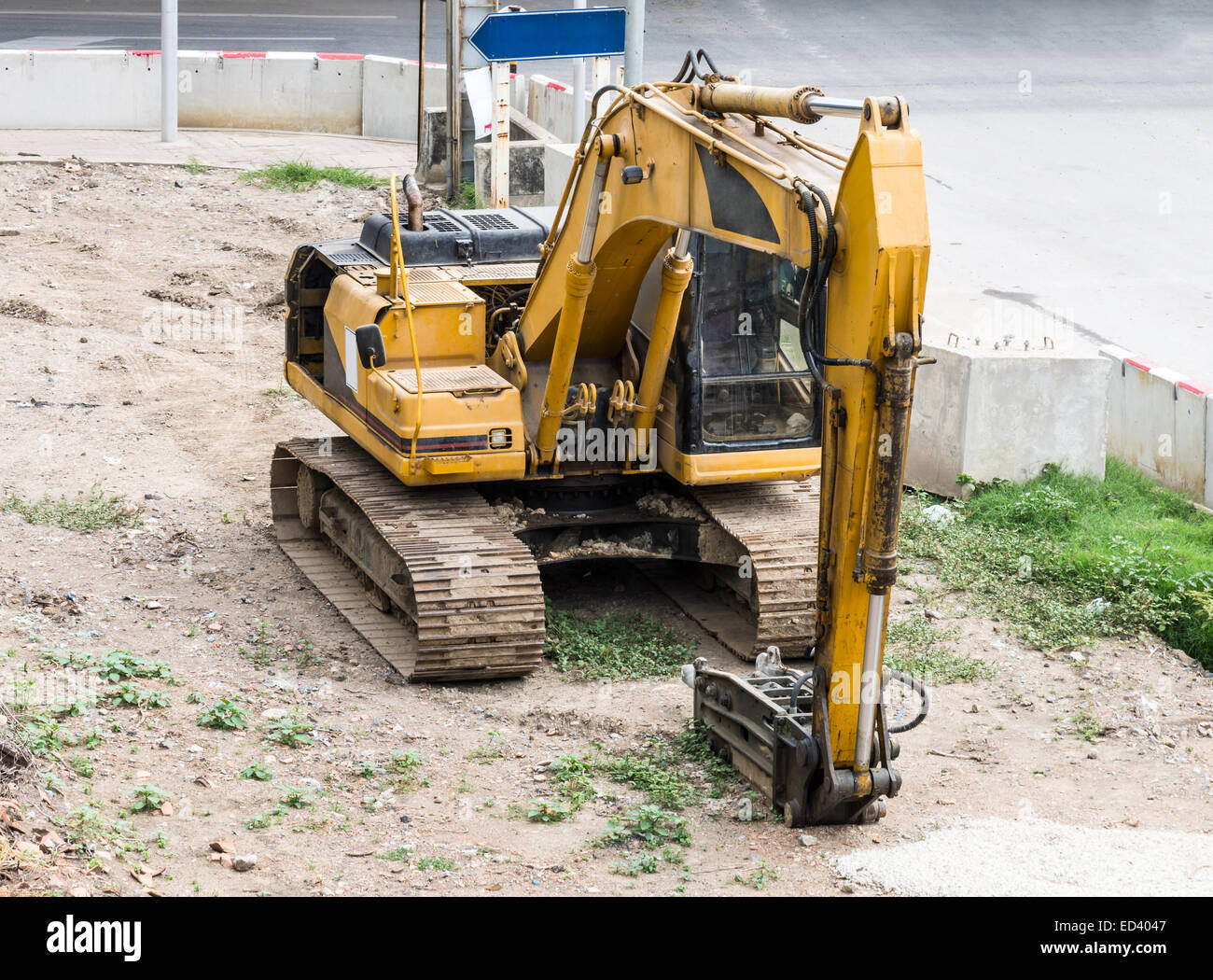 Mechanical excavator on the construction site near urban road Stock
