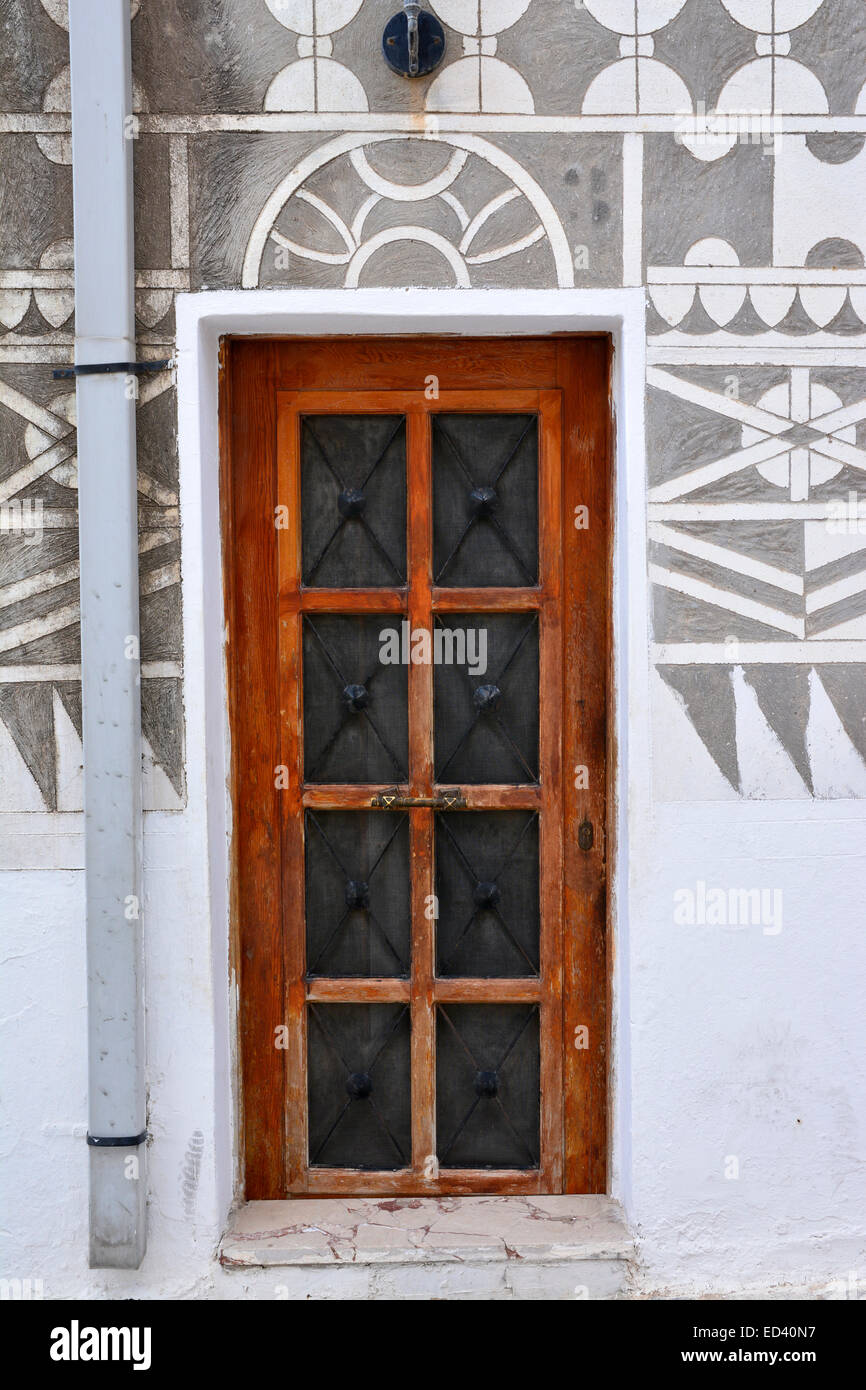 Doorway in Pyrgi, Chios, Greece, with sgraffiti wall decor adjacent. Stock Photo