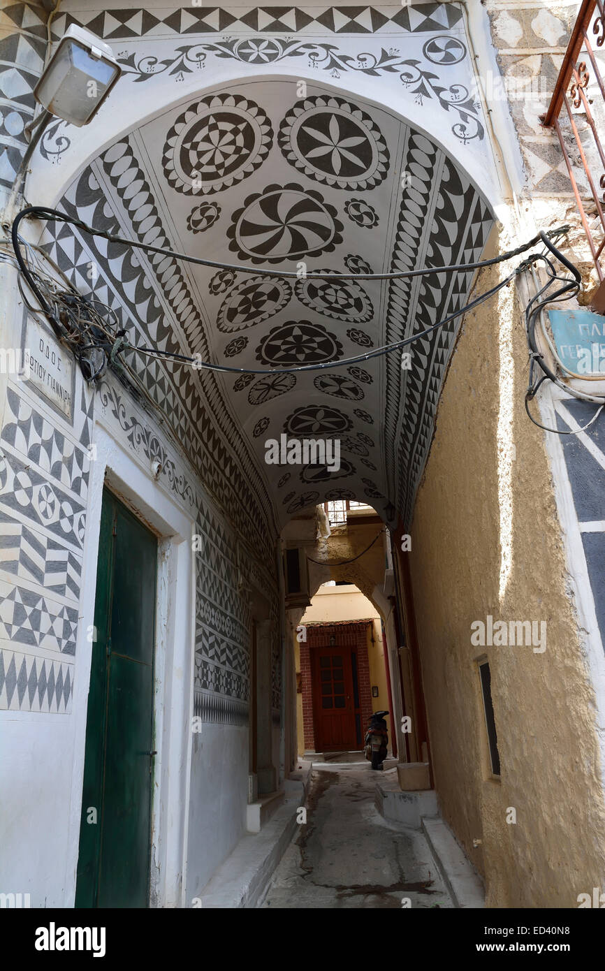 A narrow street in Pyrgi, Chios, Greece, showing sgraffiti, the local wall decoration of contrasting black and white. Stock Photo