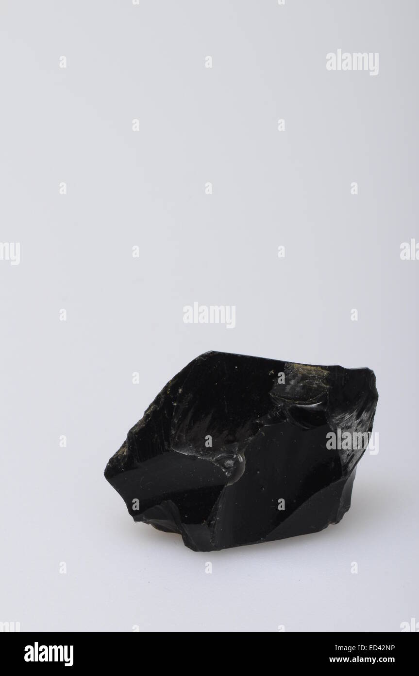 Close up of a black obsidian stone on mineral background Stock Photo