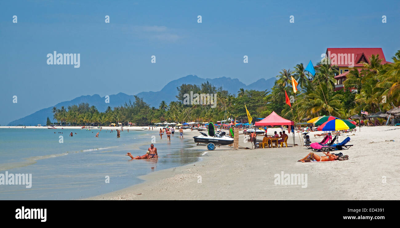 Western tourists sunbathing on white sandy beach at the west coast of Langkawi Permata Kedah, Malaysia Stock Photo