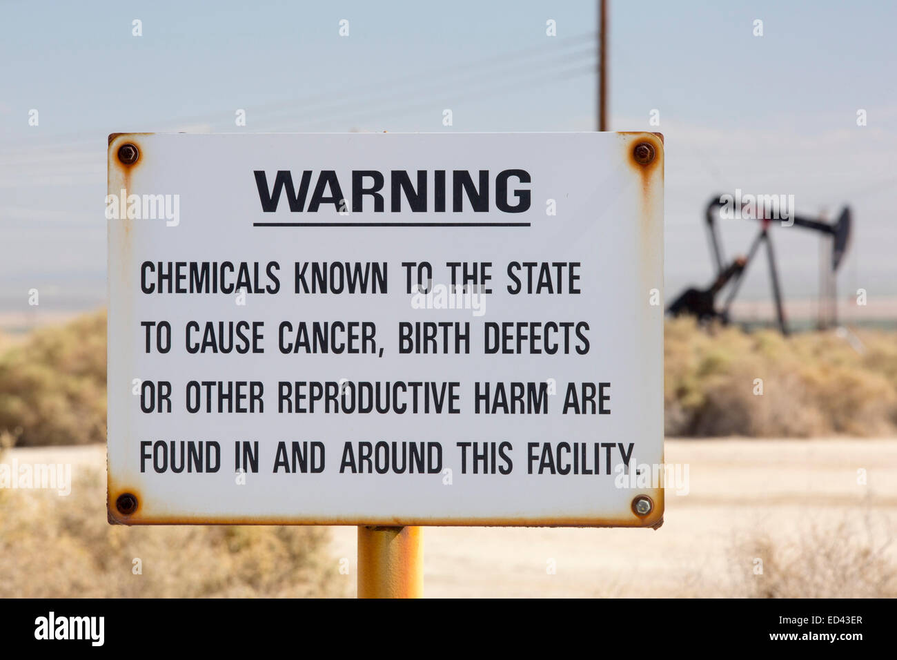 A sign about cancer and birth defects in the Midway Sunset oilfield in Maricopa, Bakersfield, California, USA. Following an unprecedented four year long drought, Bakersfield is now the driest city in the USA, driven by climate change. Still Americans fail to make the connection between their addiction to fossil fuels and climate change. Stock Photo