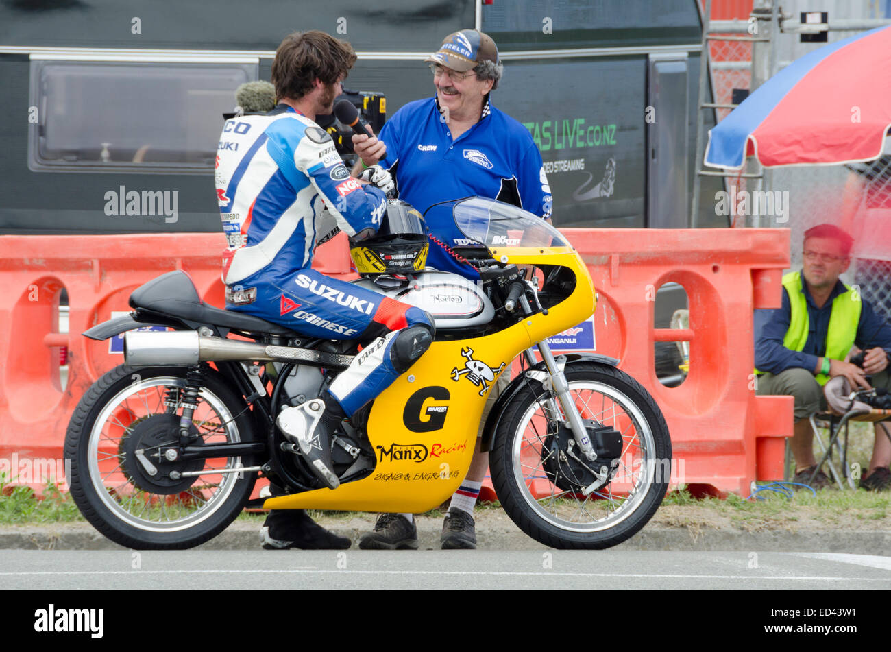 Wanganui, New Zealand. 26th Dec, 2014. Guy Martin, UK TV presenter and motorcycle racer, being interviewed for NZ TV after winning the classic solo race at the annual Boxing Day “Cemetery Circuit” event in Wanganui, New Zealand on 26 December 2014 on his vintage Manx Norton bike.  The race is part of the Suzuki Series of motorcycle racing held every summer in New Zealand.  It is an exciting day of street racing on a tight one-mile street circuit around the old town cemetery in downtown Wanganui. Credit:  Geoff  Marshall/Alamy Live News Stock Photo
