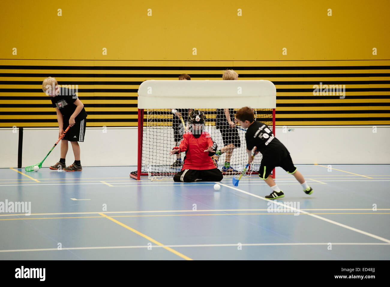 Children boys schoolchildren playing floorball (floor hockey) match in