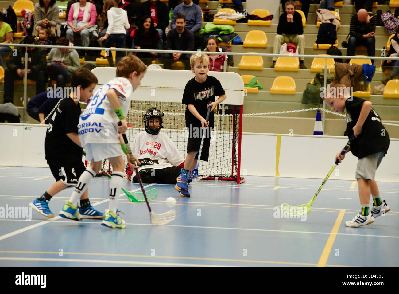 Children boys schoolchildren playing floorball (floor hockey) match in
