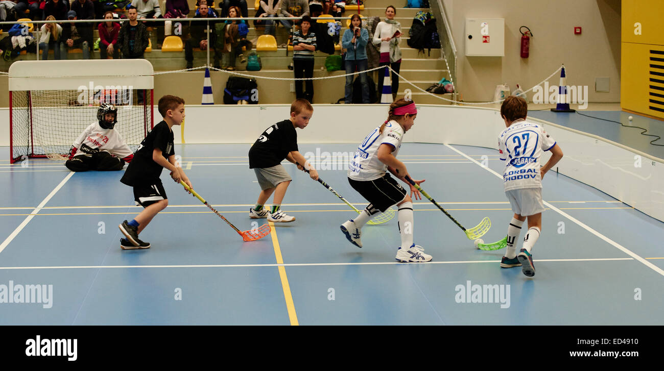 Children boys schoolchildren playing floorball (floor hockey) match in