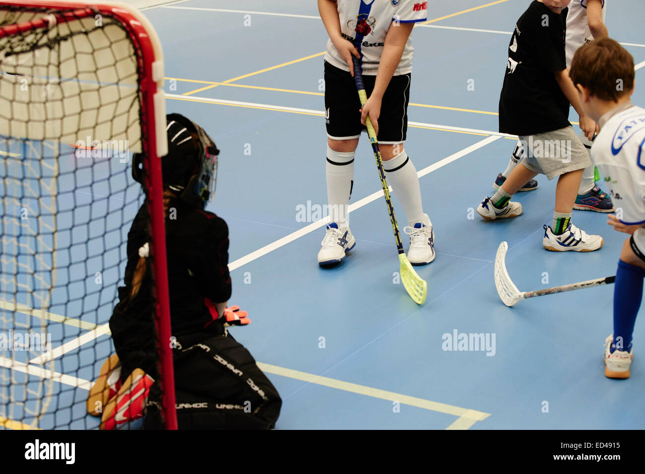 Children boys schoolchildren playing floorball (floor hockey) match in