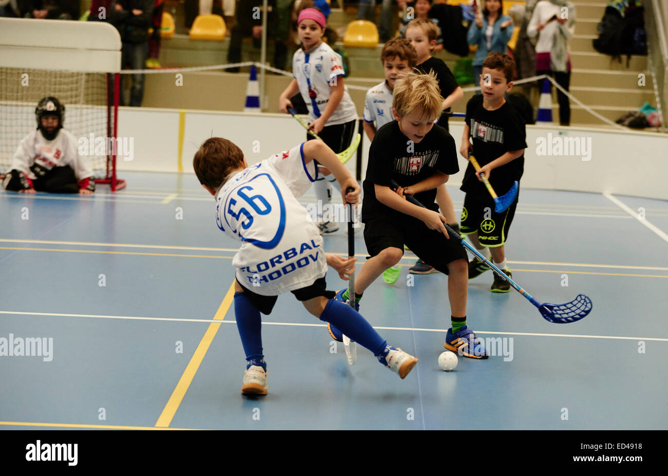 Children boys schoolchildren playing floorball (floor hockey) match in