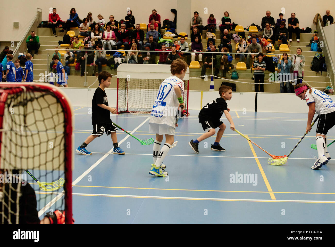 Children boys schoolchildren playing floorball (floor hockey) match in