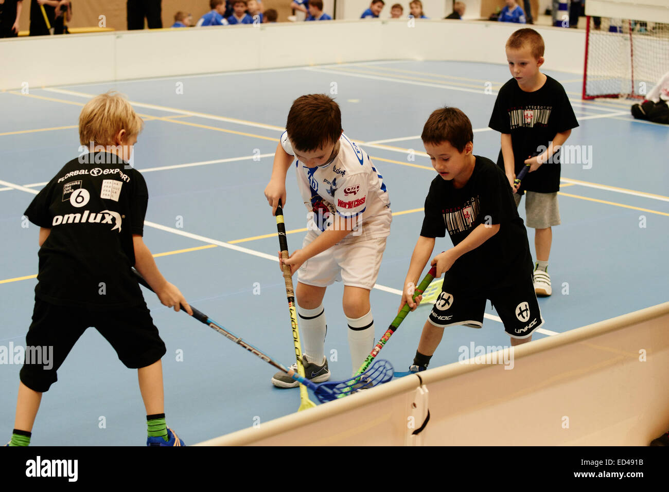 Children boys schoolchildren playing floorball (floor hockey) match in