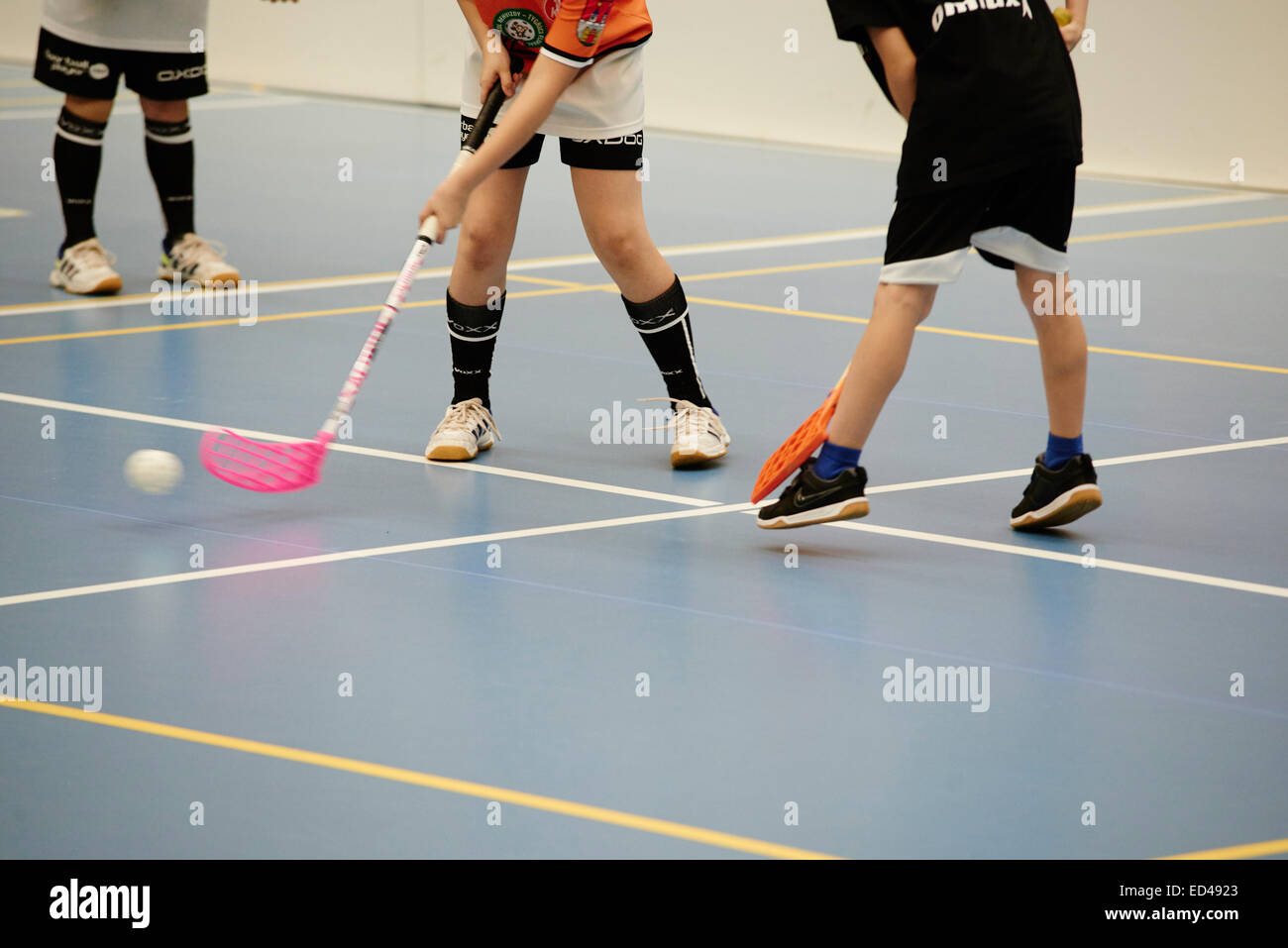 Children boys schoolchildren playing floorball (floor hockey) match in