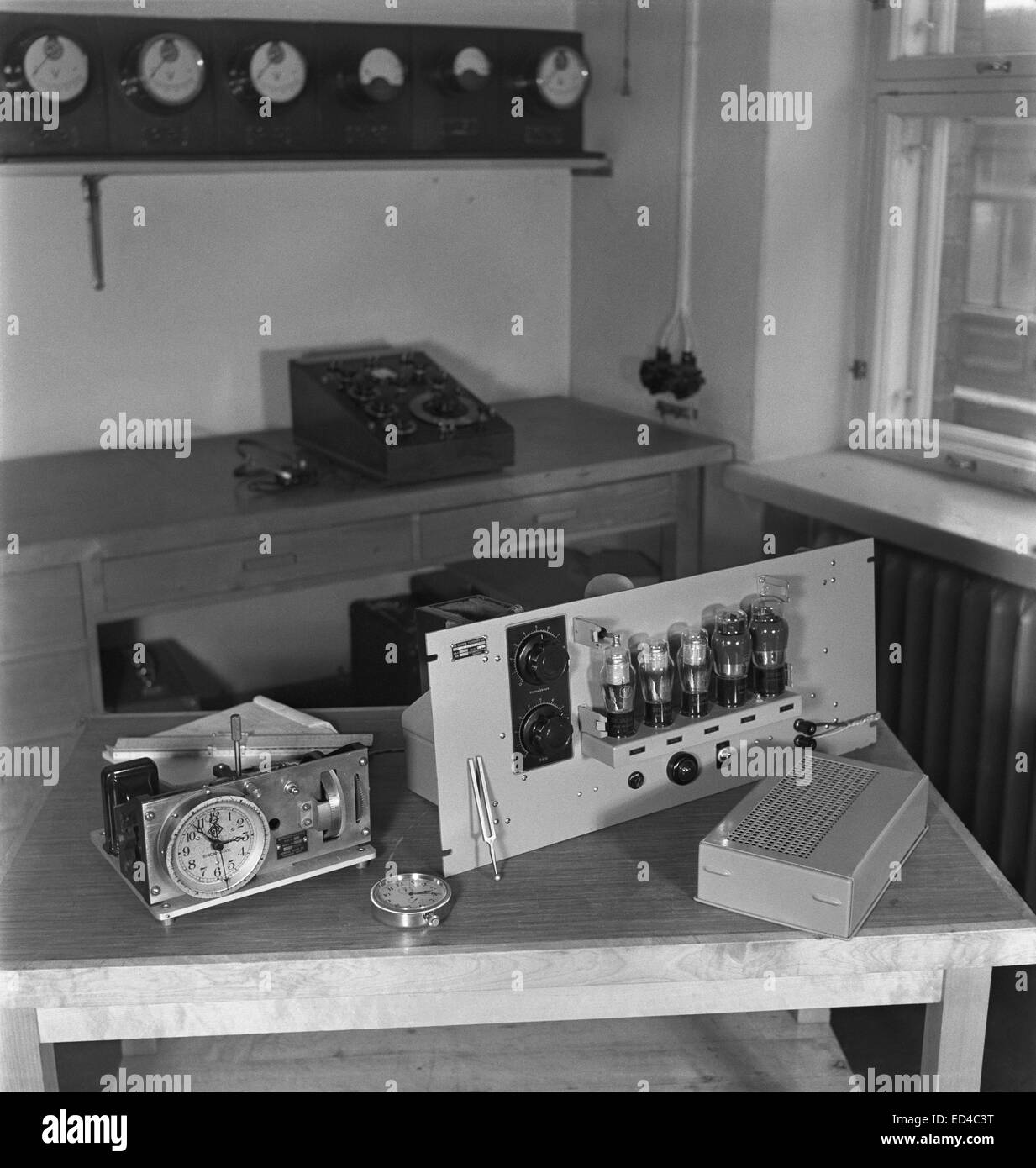The Syncro-Clock time keeper,  Yleisradio's driving clock  and a kind of radio that received the time signal from the German hydrological institute's chronometer. A radio set which controlled  several time keepers in Yle's radio house, ca. 1945. Stock Photo