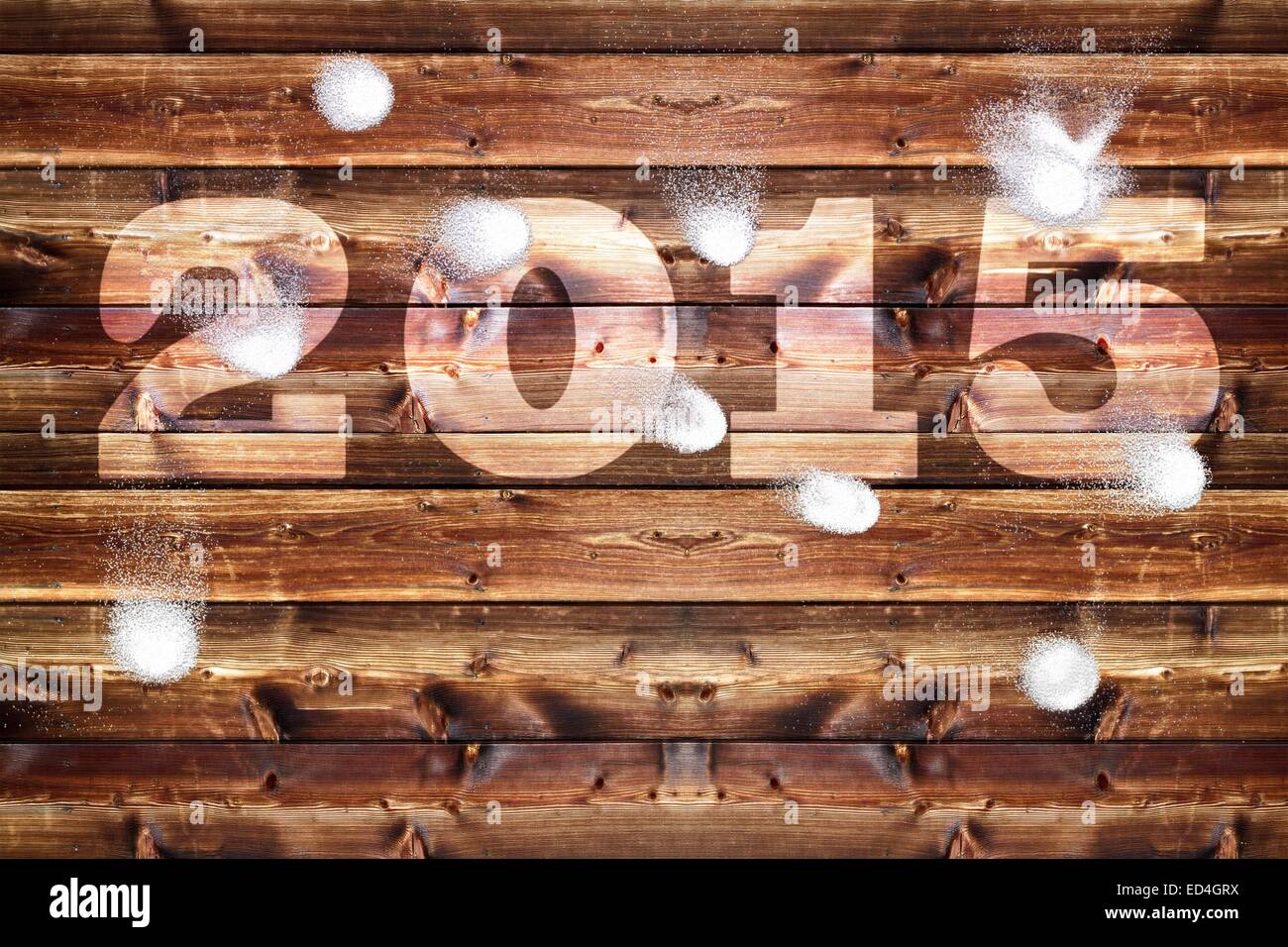 Wooden board with bleached out 2015 letters, which is bombarded with snowballs. Stock Photo