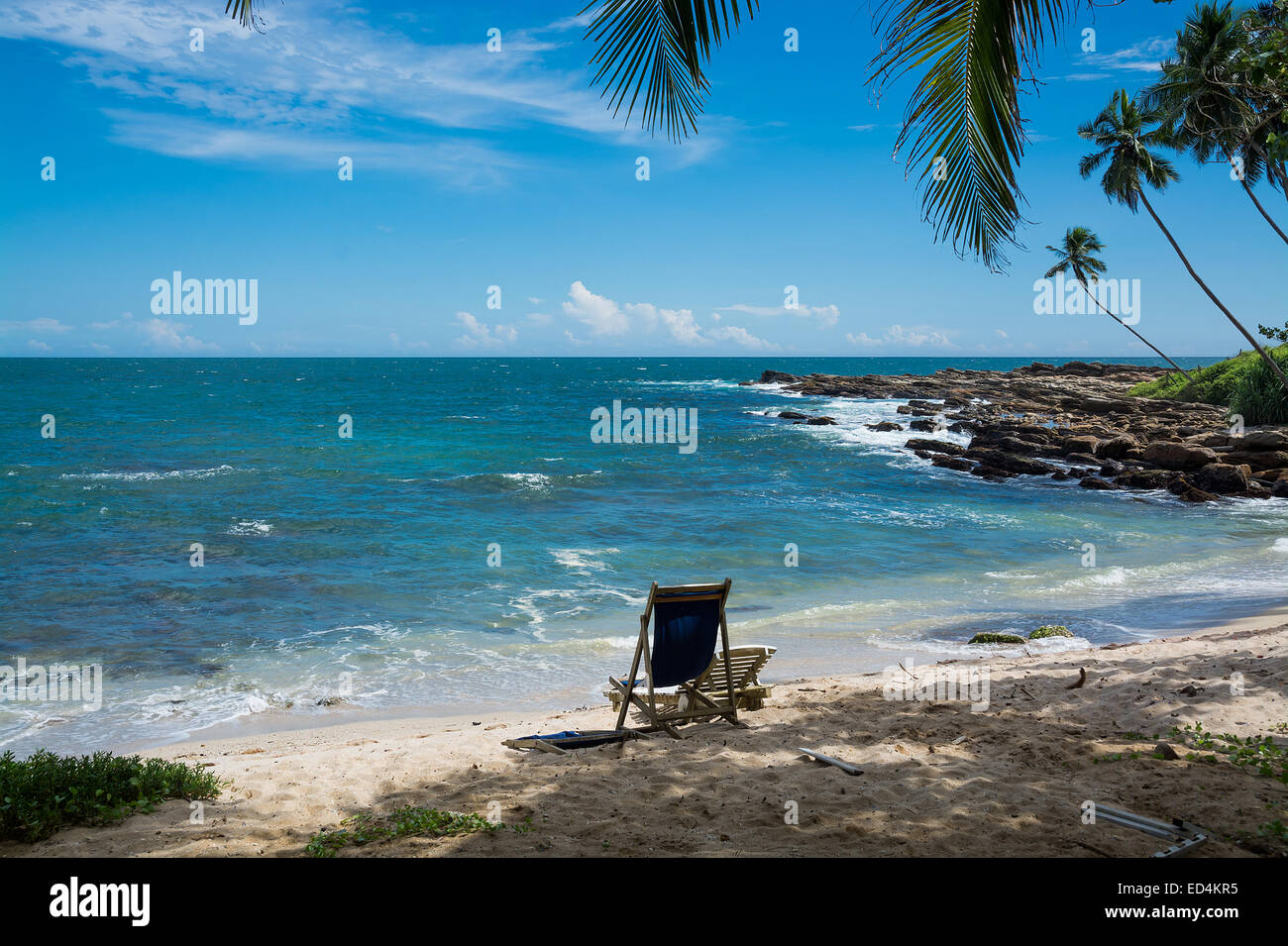 Tropical rocky beach with coconut palm trees, sandy beach and ocean. Tangalle, Southern Province, Sri Lanka, Asia. Stock Photo