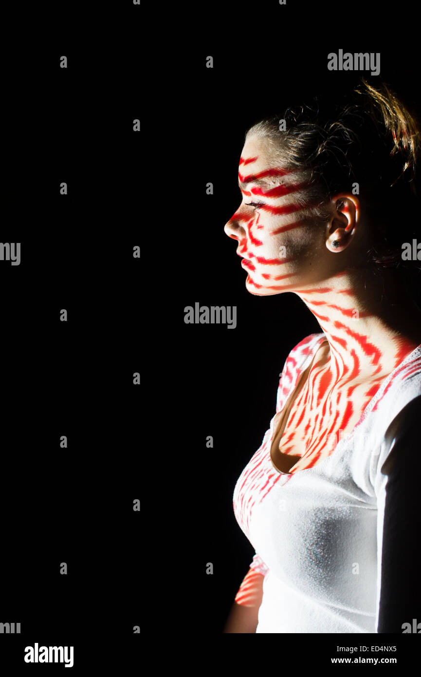Digital Art: a young woman girl in profile with digital fingerprint image pattern projected onto her face. Stock Photo