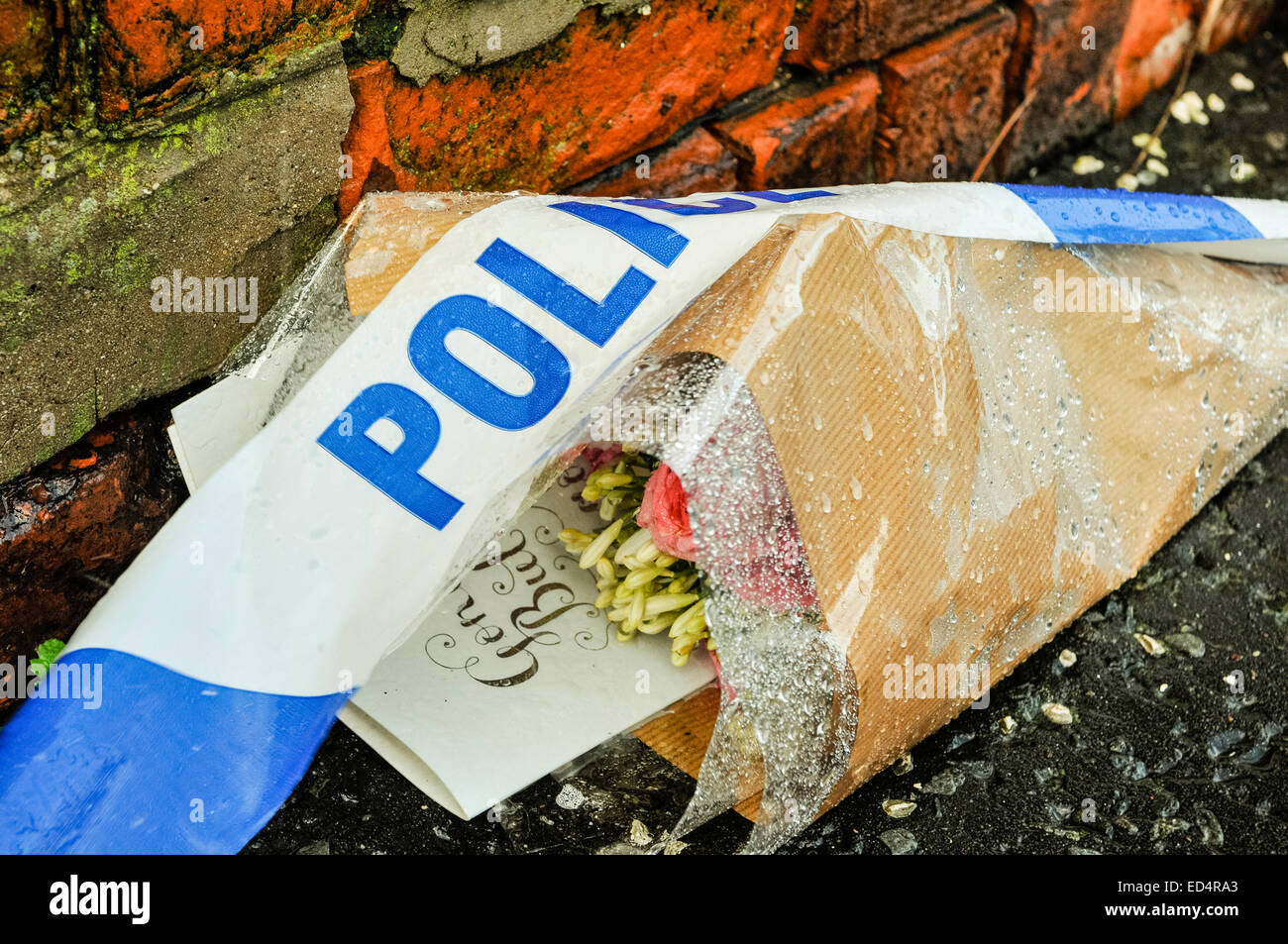Belfast, Northern Ireland. 27 Dec 2014 - Police tape lies over flowers outside a home where a murder had occurred Credit:  Stephen Barnes/Alamy Live News Stock Photo