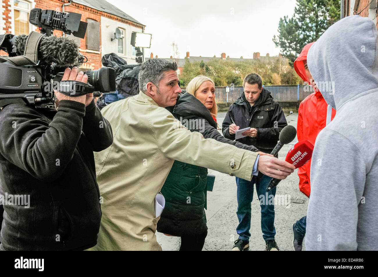 Belfast, Northern Ireland. 27 Dec 2014 - Television reporters and journalists record the reaction of two young men following a murder. Credit:  Stephen Barnes/Alamy Live News Stock Photo