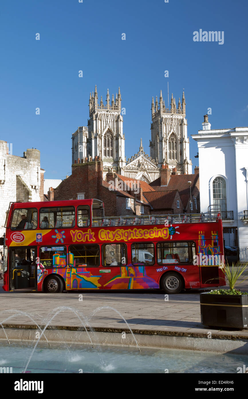 A red double decker sightseeing bus in St Leonards Place York, and York Minster, North Yorkshire, England. Stock Photo