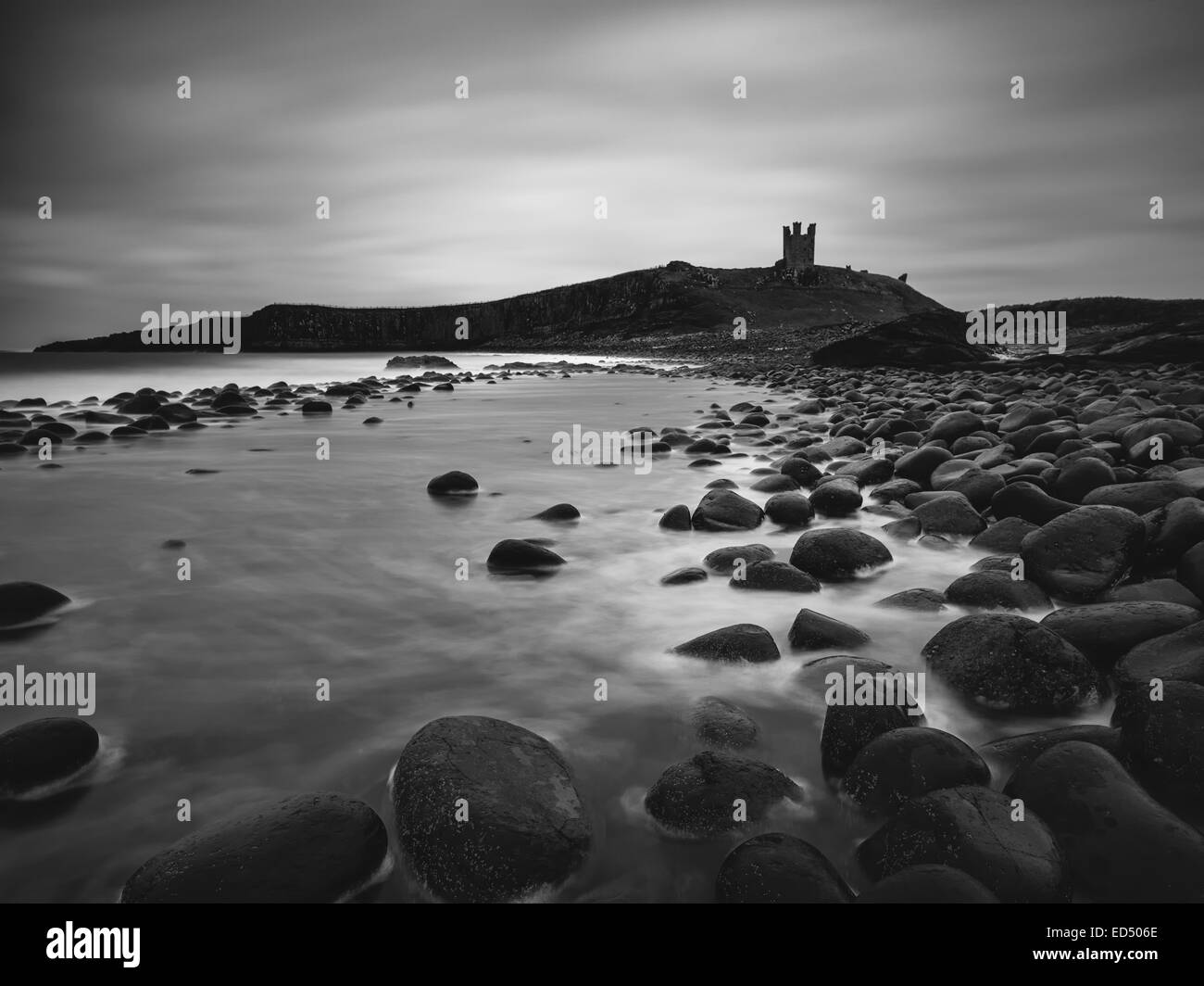 A view of Dunstanburgh Castle from Embleton Bay. A one minute exposure converted to monochrome. Stock Photo