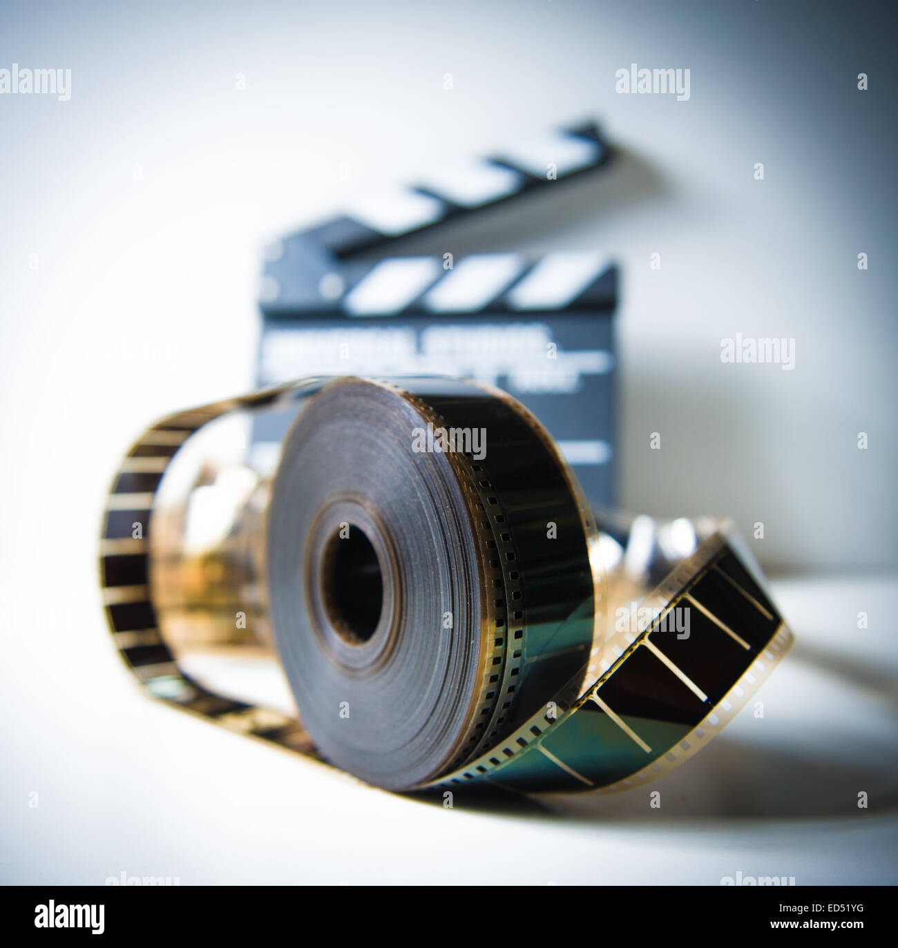 35mm movie reel with out of focus clapper in background, color effect and  vintage look Stock Photo - Alamy