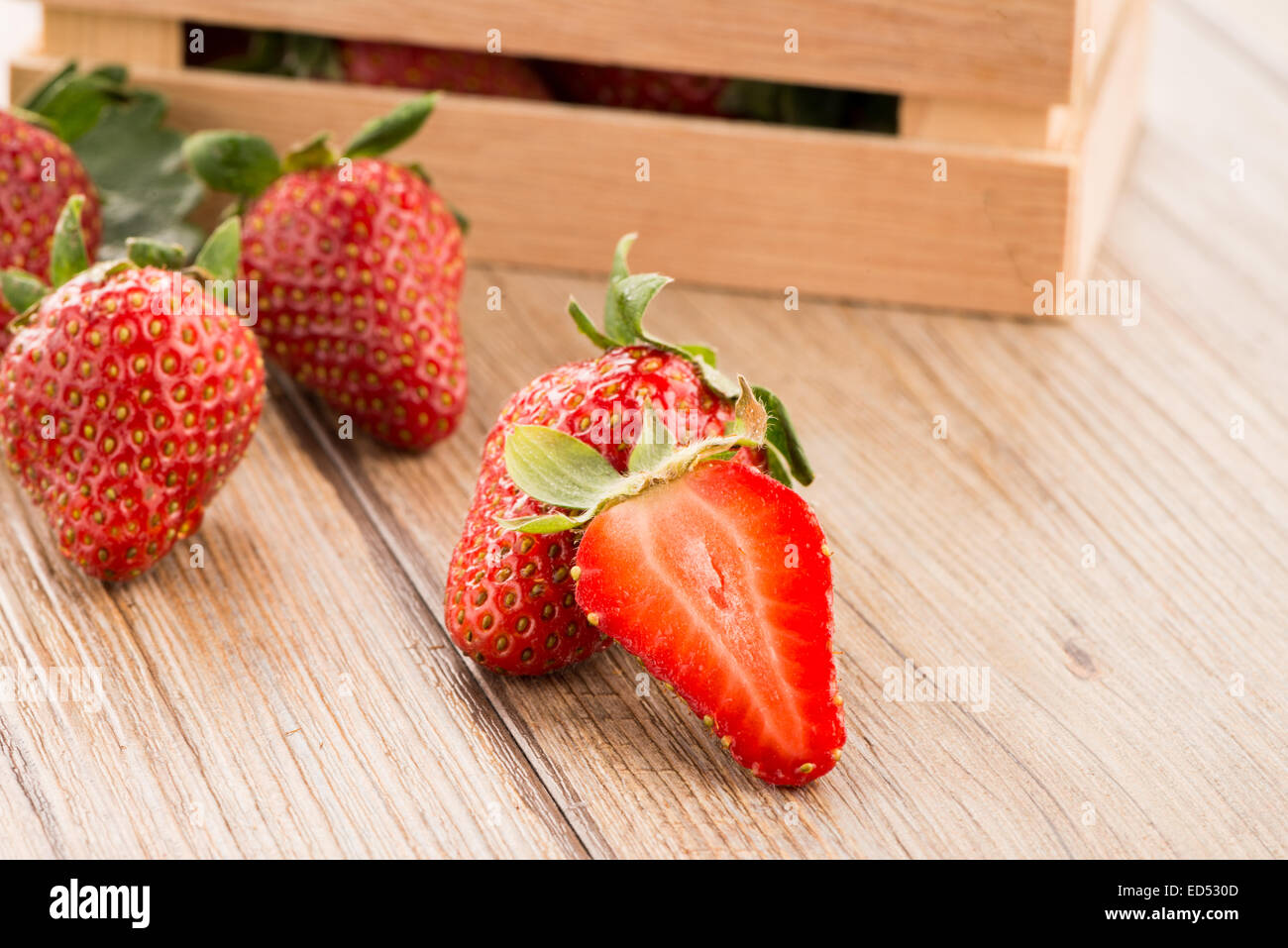 Strawberries over odl brown wooden table background Stock Photo - Alamy