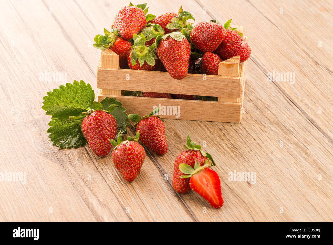 Strawberries over odl brown wooden table background Stock Photo - Alamy