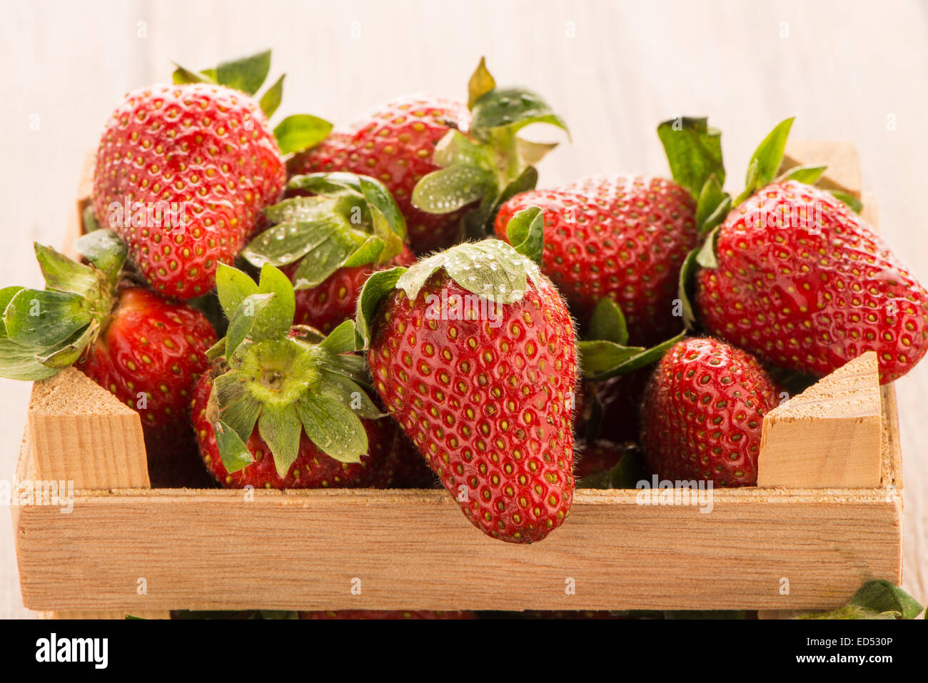 Strawberries over odl brown wooden table background Stock Photo - Alamy