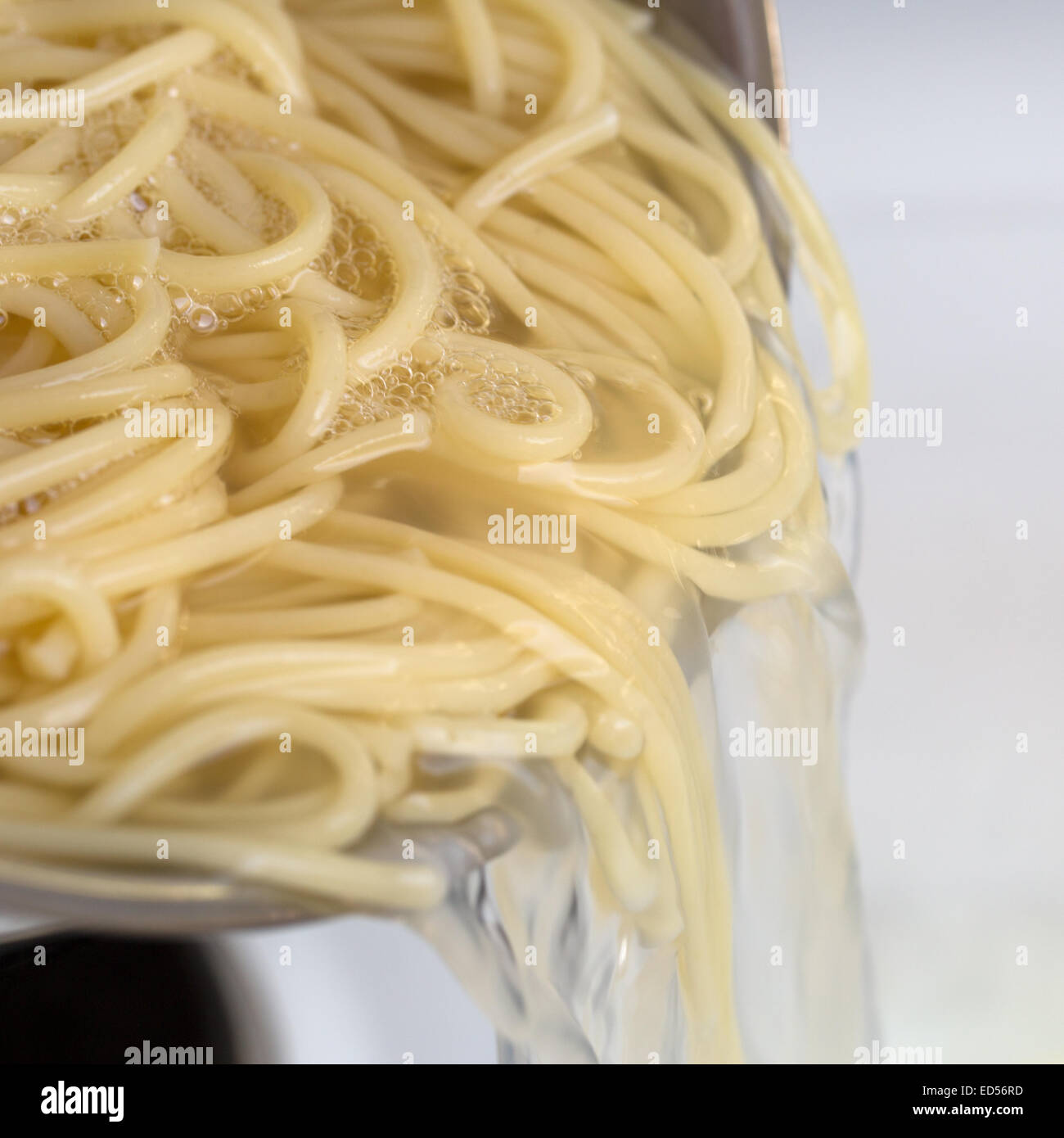 Cooking spaghetti noodles food meal strain the pasta from hot water Stock Photo