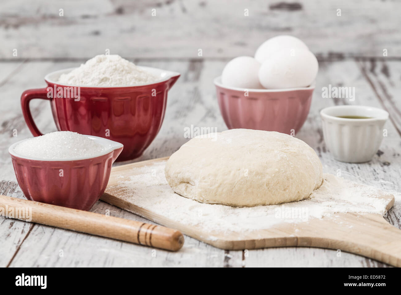 Dough recipe ingredients like eggs, flour, oil, sugar on white wooden