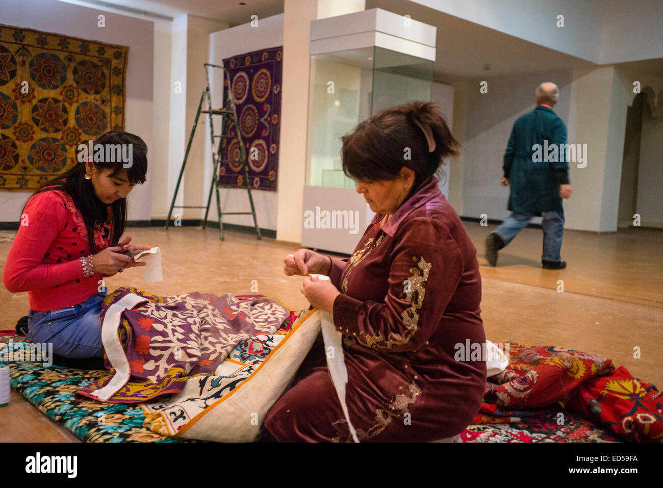 Museum workers line suzani, traditional Uzbek embroidery textile, for exhibition in new building of Samarkand State Memorial Mus Stock Photo