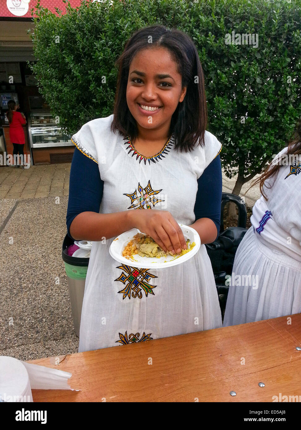 Young Ethiopian Jew in traditional dress and a plate of Ethiopian food Stock Photo