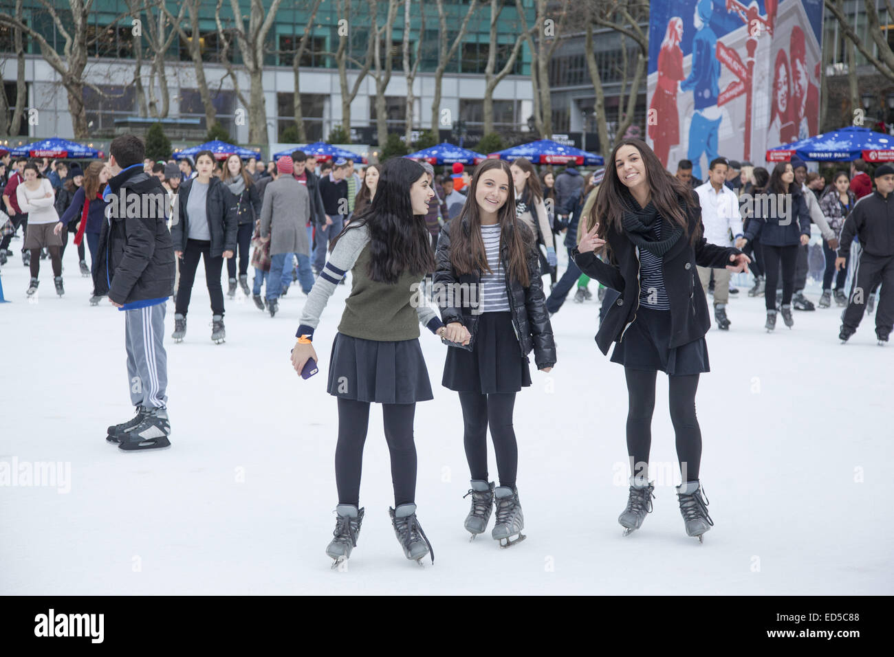 People enjoy the holiday season ice skating at Bryant Park in midtown Manhattan, NYC. Stock Photo