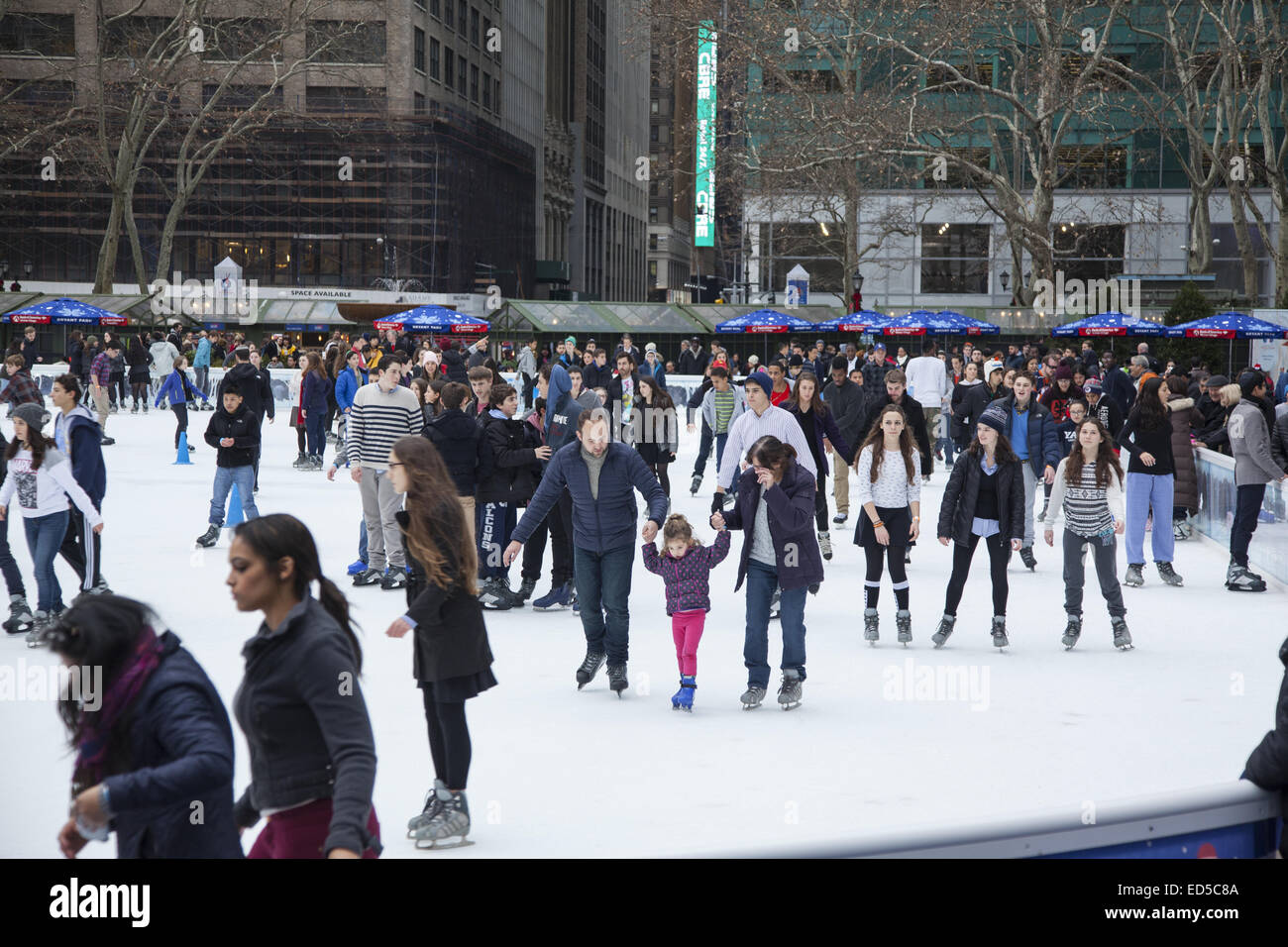 People enjoy the holiday season ice skating at Bryant Park in midtown Manhattan, NYC. Stock Photo
