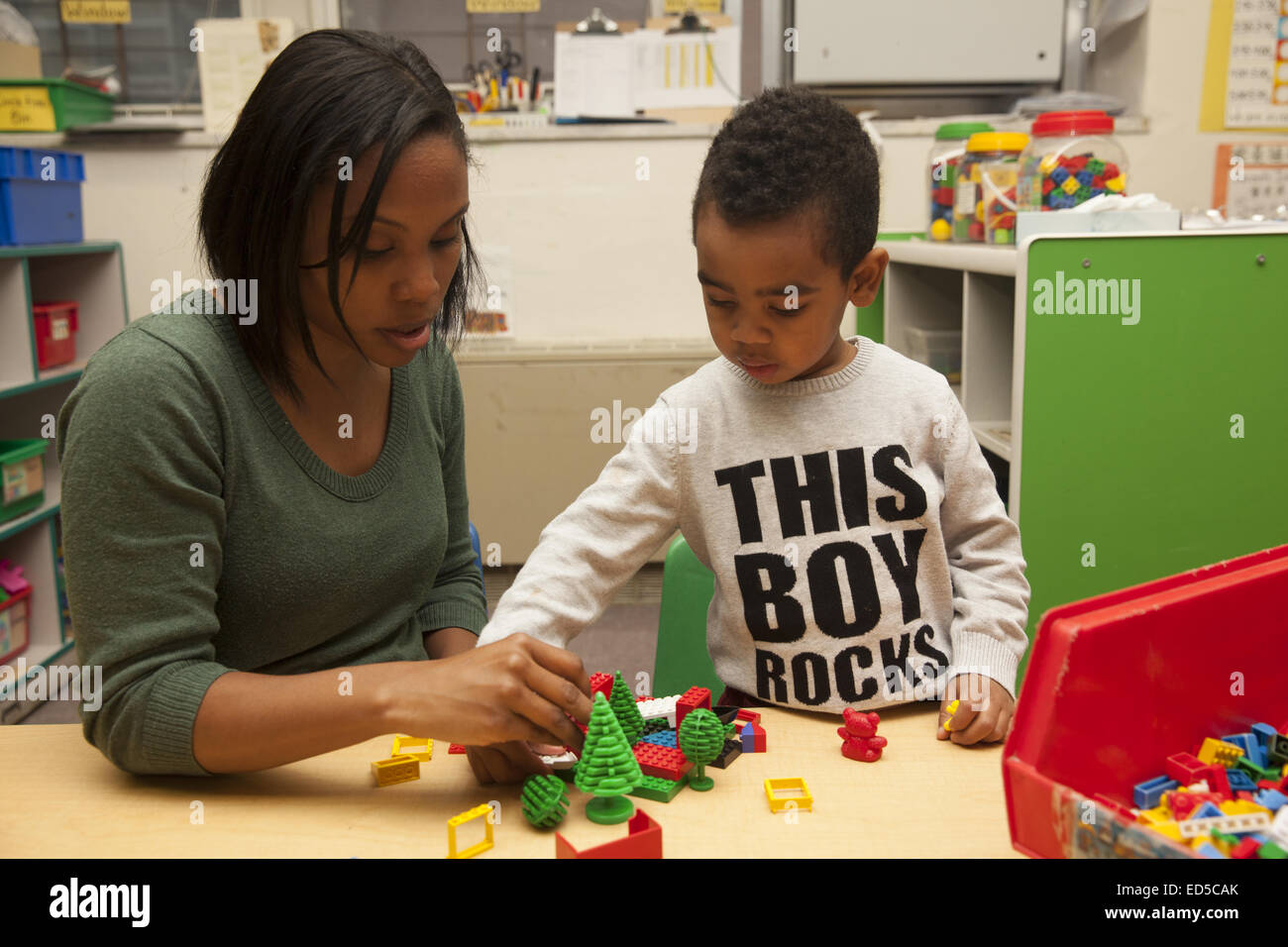 Day Care nursery school on the Lower East Side of Manhattan. Teacher works with child. Stock Photo
