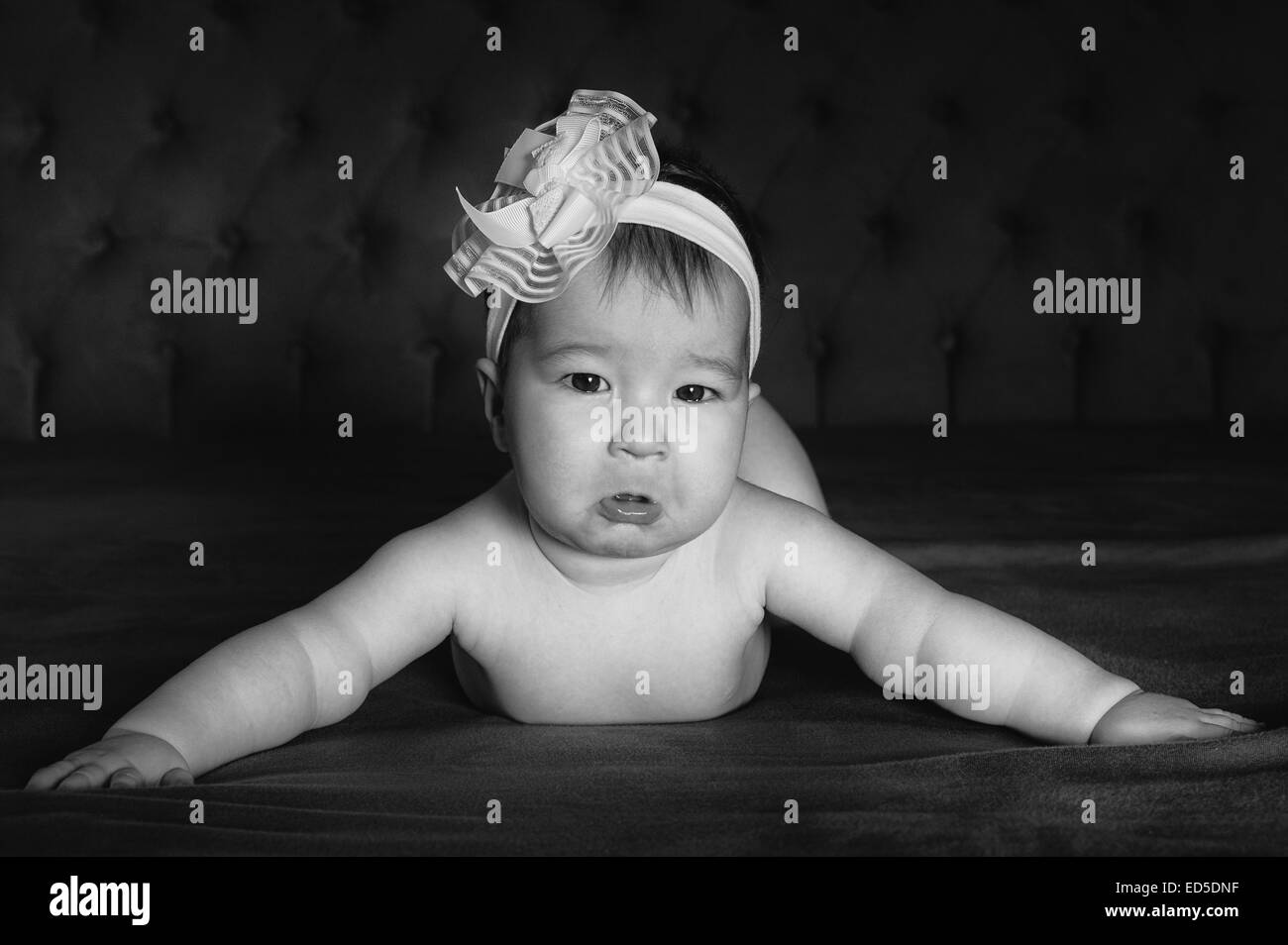 baby girl crying arms open on the bed black and white bw photo Stock Photo