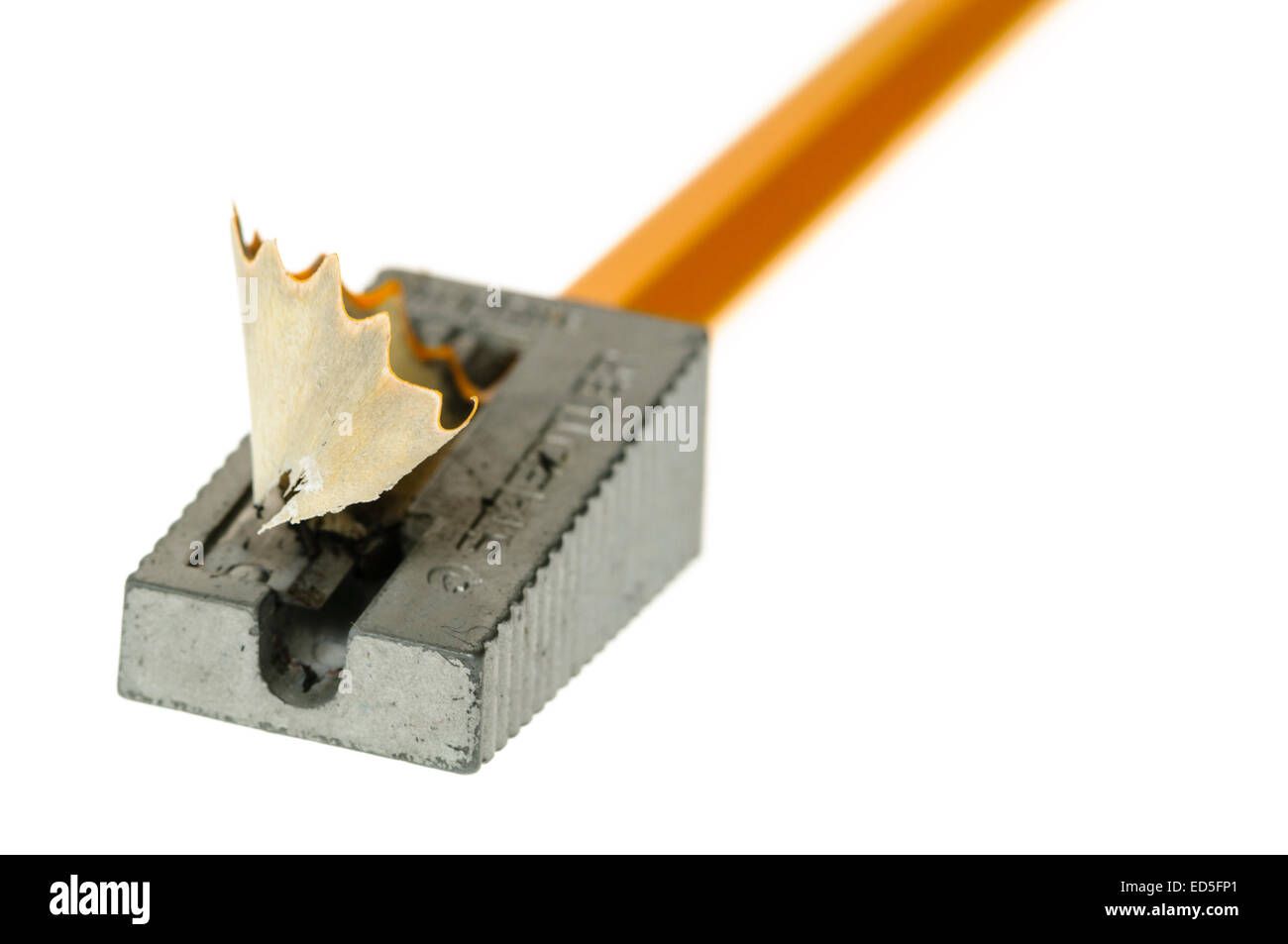 Pencil being sharpened with a small metal handheld sharpener Stock Photo